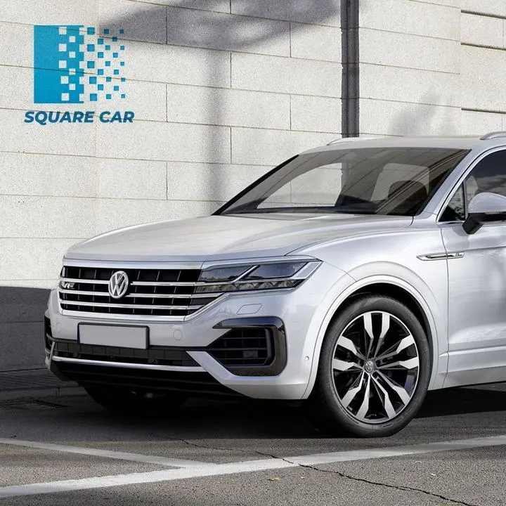 Volkswagen Touareg blanc devant un mur de pierre, logo Square Car en haut à gauche